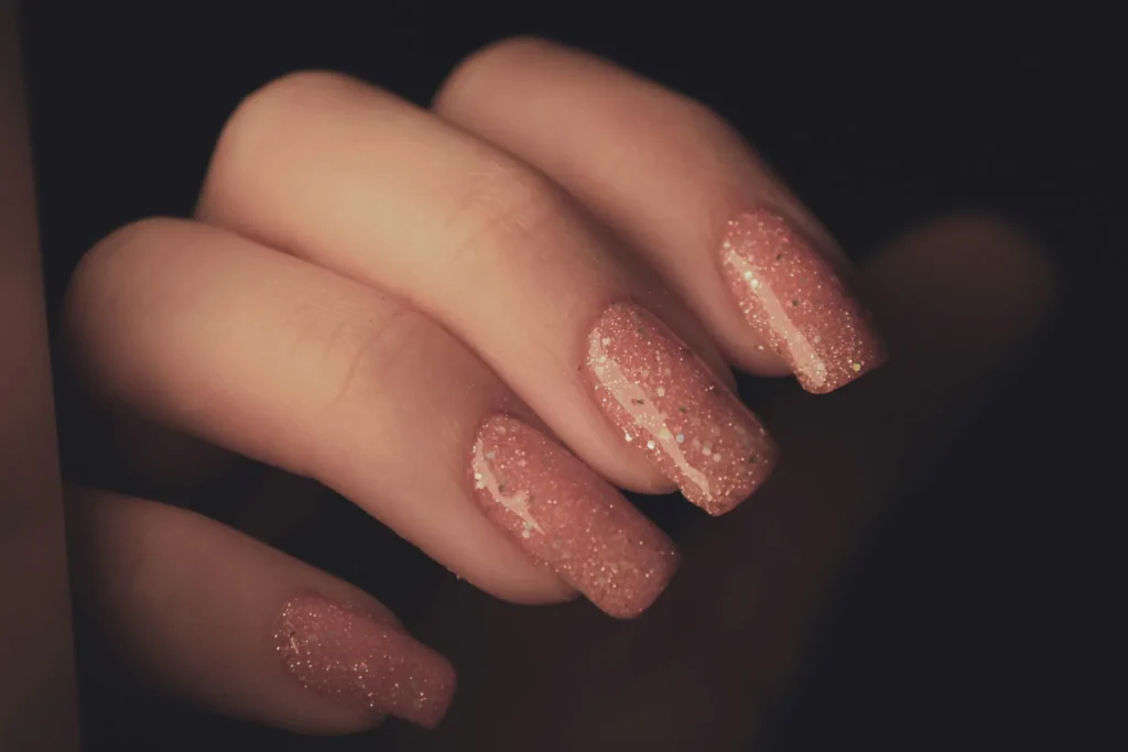 a woman's hand with a pink manicure