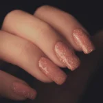 a woman's hand with a pink manicure