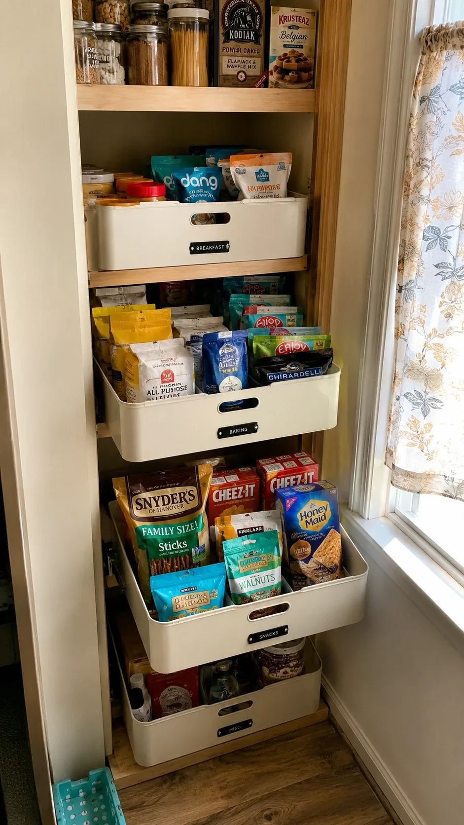 Labeled pull-out pantry bins for breakfast, baking, and snacks on deep shelves